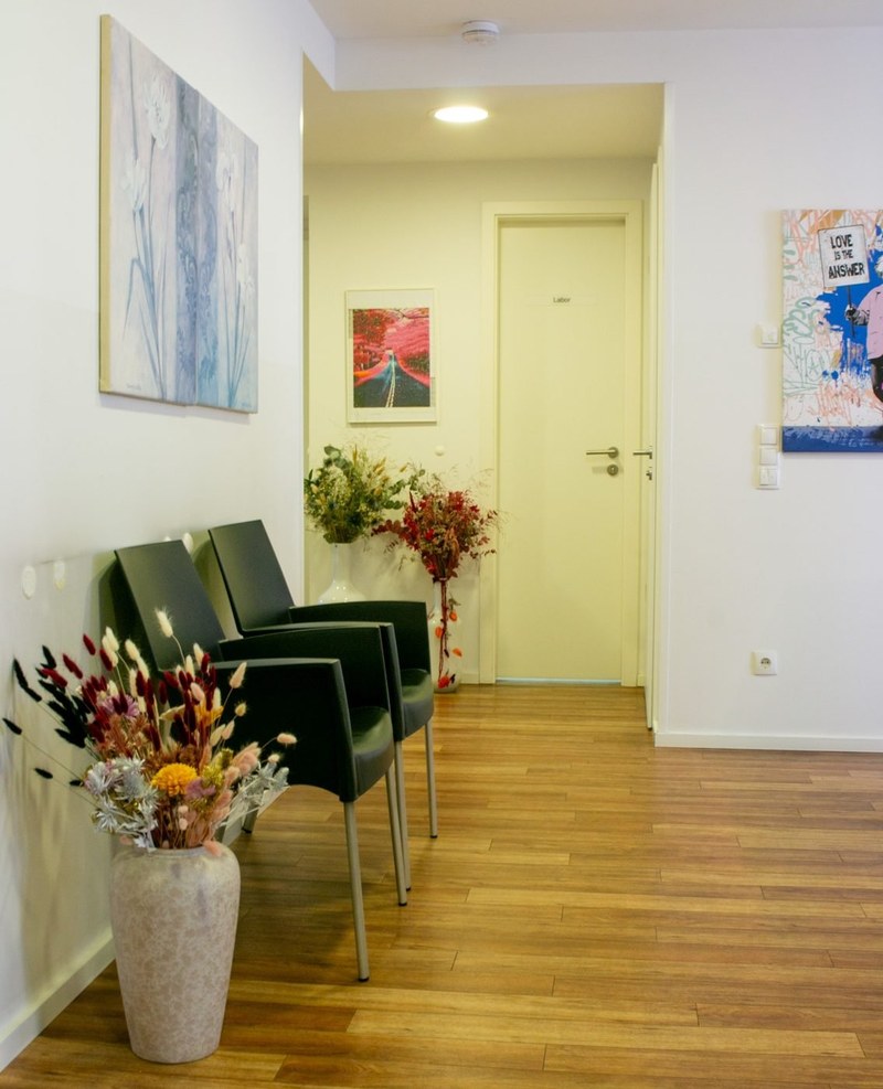 Heller Praxisflur mit Sitzgelegenheiten und Bildern
